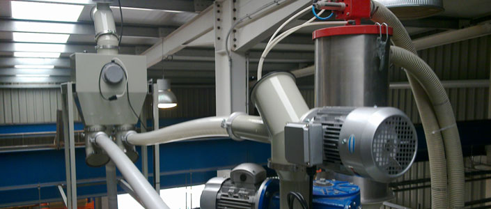 Alimentació pneumàtica centralitzada de la matèria primera principal i alimentació mecànica flexible del material triturat a un mesclador sobre unes extrusores de tub.